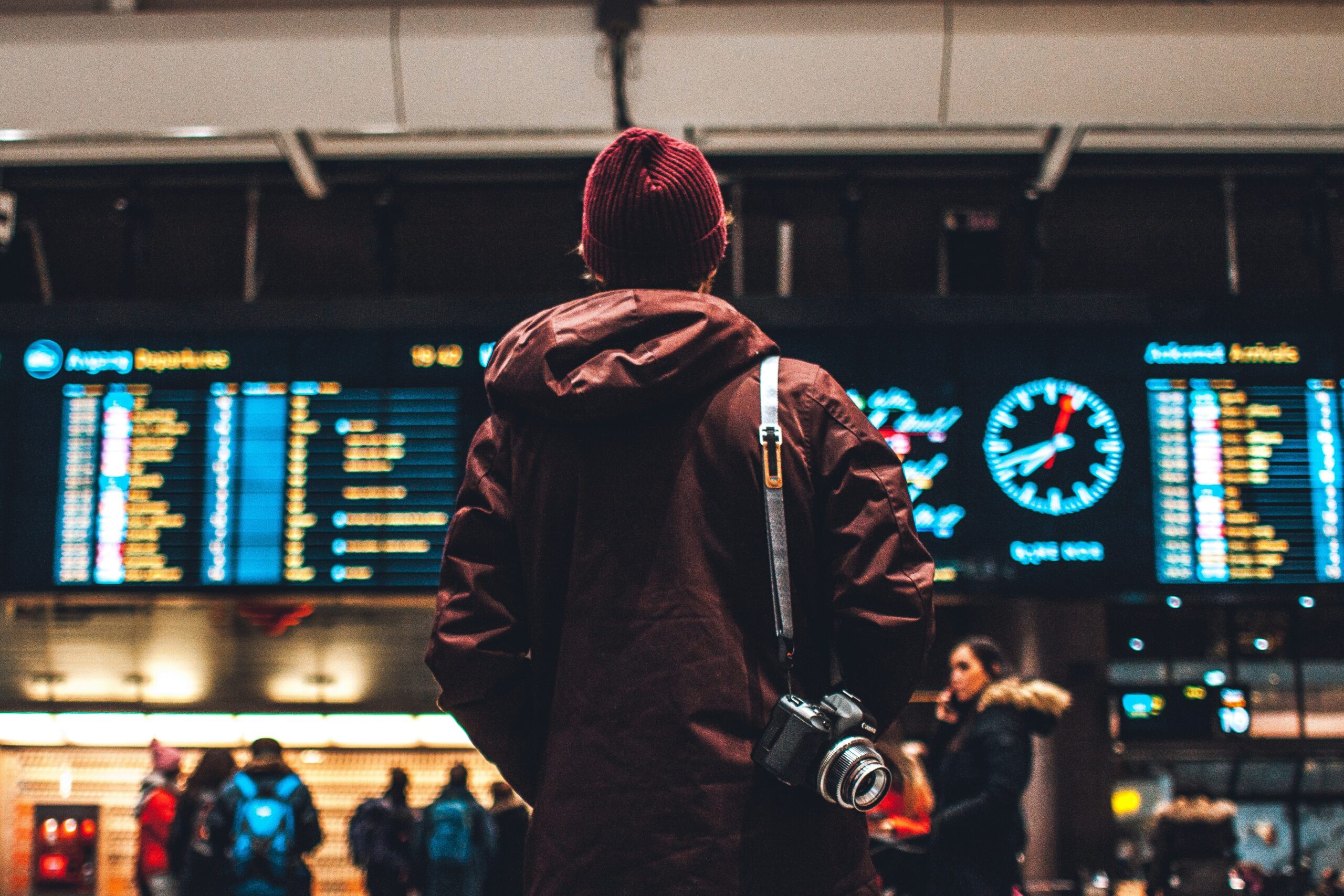 Ragazzo guarda il tabellone con gli orari alla stazione di Oslo in Norvegia